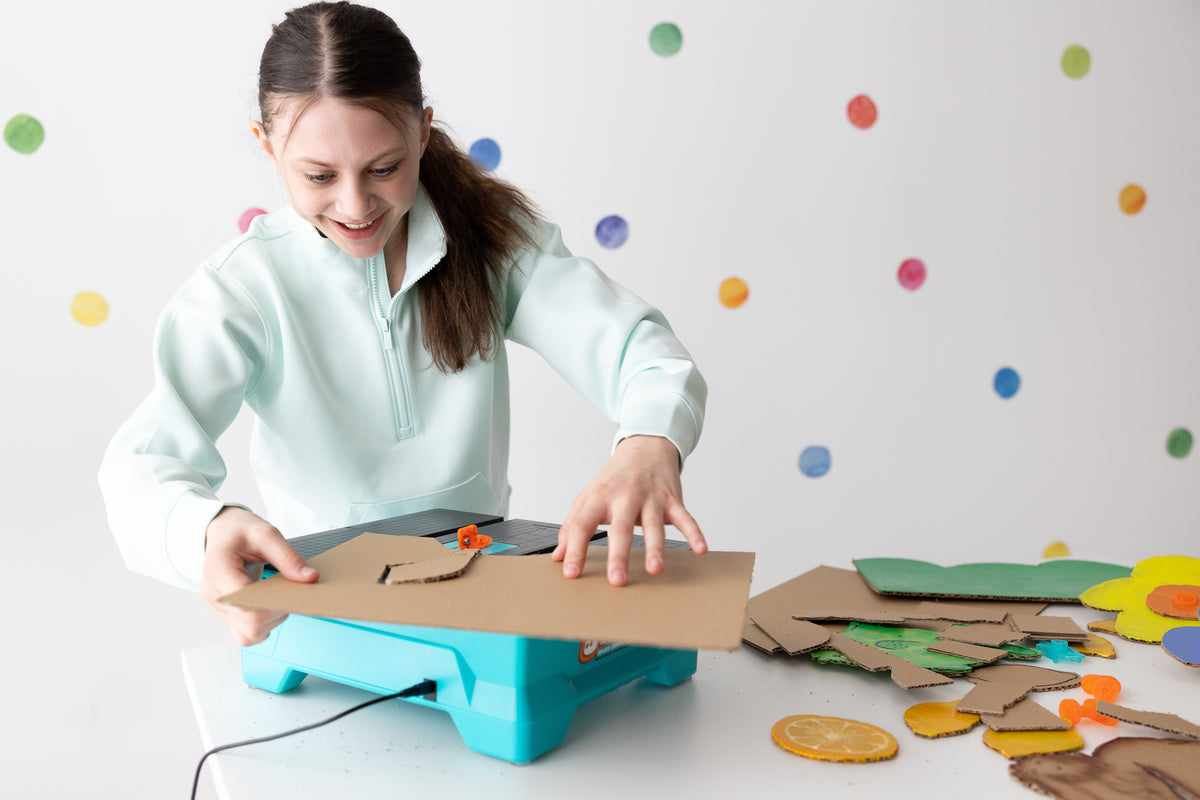 Girl cutting cardboard shapes with the Swift Saw
